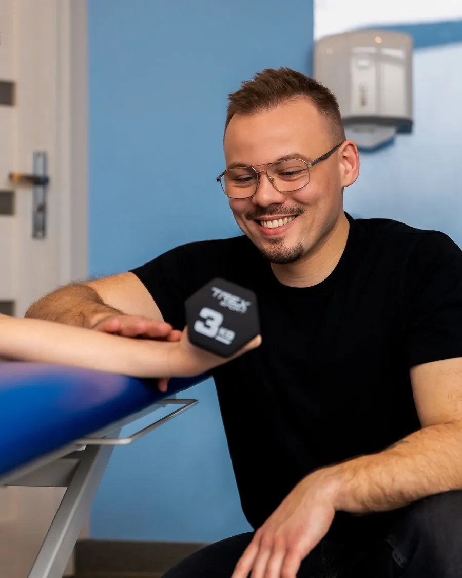 Mateusz Koszałka, fizjoterapeuta, w gabinecie z pacjentem